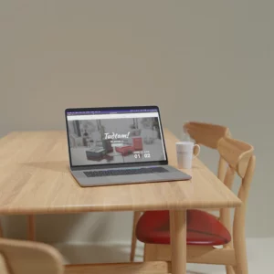 Bilden visar hur hemsidan för Tudtam ser ut på en bärbar dator, på bordet står en kaffekopp med Pivemo-logo